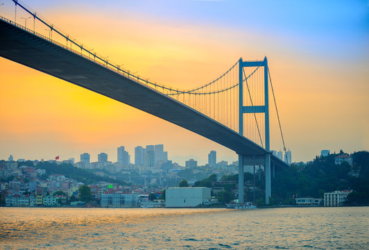 bridge through the Bosphorus strait in the evening on a sunset, on a background business cent of Istanbul
