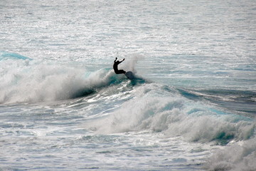 Silhouette of a surfer riding a wave in Waimea Beach, North shore of Oahu, Hawaii