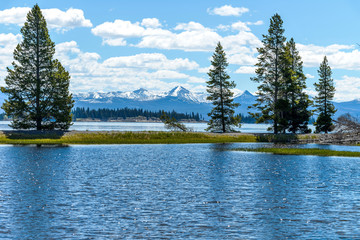 Yellowstone Lake - A spring view of Yellowstone Lake with snow-capped mountain range in the...