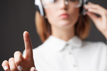 Young businesswoman pressing high tech type of modern buttons