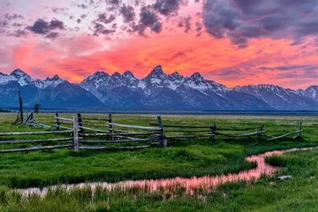 Papier Peint photo Chaîne Teton Sunset at Grand Teton - A panoramic view of a spectacular spring sunset at Teton Range, seen from an abandoned old ranch in Mormon Row historic district, in Grand Teton National Park, Wyoming, USA. 