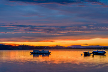 Obraz premium Sunset Spring Lake - Evening Twilight lights up spring stormy sky over a quiet bay of Jackson Lake in Grand Teton National Park, Wyoming, USA. 