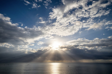 Sunset with Stormy clouds and sunbeam over the sea. Dramatic sky background