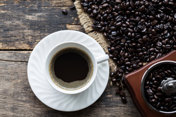 white coffee cup with Coffee beans On the old wooden background