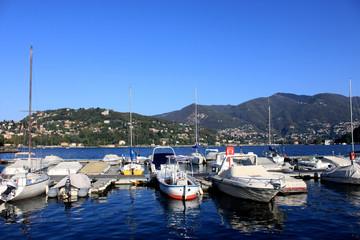 Fototapeta na wymiar Boats along the coast in Lenno, Como lake, Italy. Beautiful touristic place
