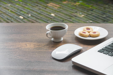 Top view home office table with laptop, coffee and cookie on wooden table. Modern office top view at home. New life style. Concept : business and office.
