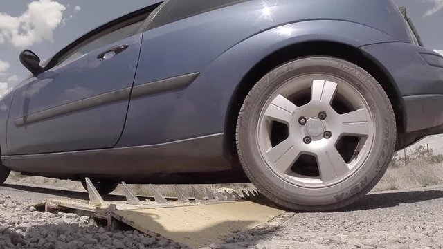 Low Angle Car Driving Over Road Spikes