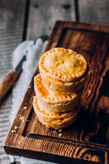 Fresh Traditional Australian meat mini pie on the wooden board on table background, closeup with...