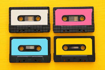 Retro cassette tape collection over yellow wooden table. top view. copy space