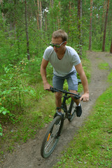 Obraz premium a cyclist on a mountain bike rides through the carriageway along the asphalt road. A healthy lifestyle. A lovable sports hobby