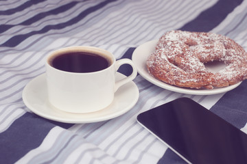 Breakfast in bed with a phone, toned photo