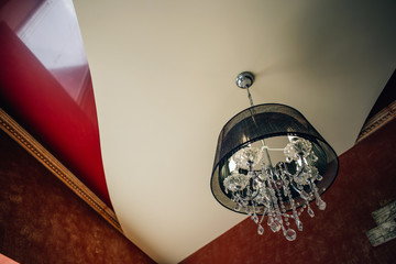 Crystal chandelier with a black lamp shade in an interior of Artdeco