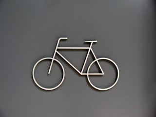 Bicycle storage room sign on a grey metal door