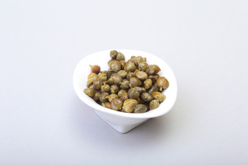 bowl with fresh capers isolated on white background.