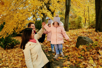Fototapeta premium Happy family playing in the autumn in the park