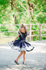 Adorable little school girl have fun outdoor. Back to school.