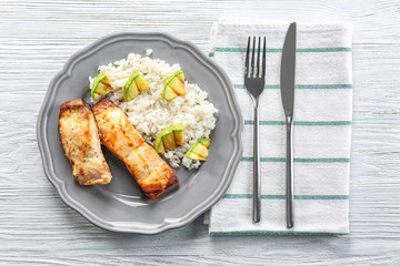 Delicious roasted salmon fillets with rice and vegetable on plate