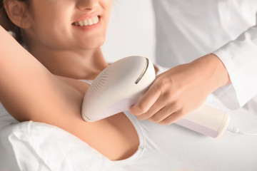 Young woman undergoing epilation procedure in beauty salon, closeup