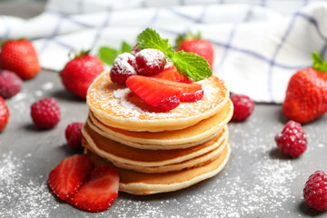 Delicious pancakes with raspberry and strawberry on table