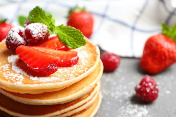Delicious pancakes with raspberry and strawberry on table