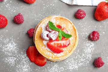 Fototapeta na wymiar Delicious pancakes with raspberry and strawberry on table