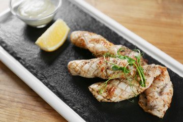 Slate plate with delicious squids on table