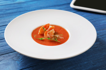 Delicious soup with shrimps in plate on table