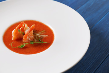 Delicious soup with shrimps in plate on table