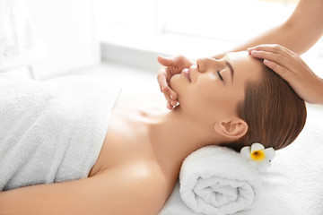 Obraz na płótnie Canvas Young woman enjoying of facial massage in spa salon