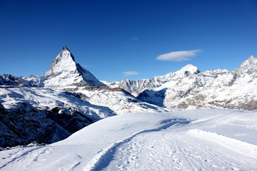Fototapeta na wymiar Scenic view on snowy Matterhorn peak in sunny day with blue sky and some clouds in background