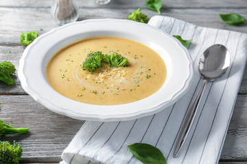 Broccoli cheddar soup in bowl on wooden kitchen table