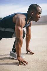 Obraz premium African runner preparing to start on concrete road