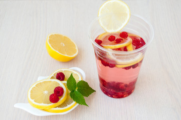 Lemon slices, drink, berries and raspberry leaves