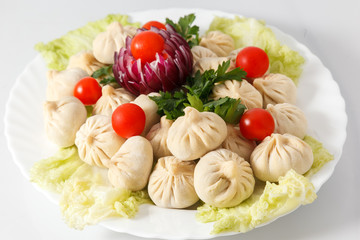 Frozen dumplings on the white plate with green