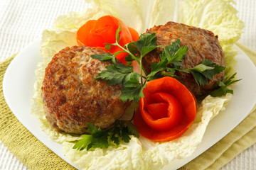 Beef cutlets with greens and vegetables on the plate