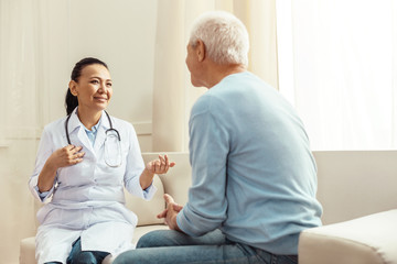 Delighted positive nurse talking to her patient