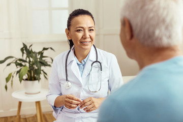 Obraz premium Cheerful skillful doctor doing her job