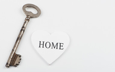 Top view of a white heart next to a wrench on white background. Isolated. Copy space.