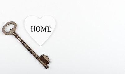 Top view of a white heart next to a wrench on white background. Isolated. Copy space.