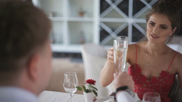 Couple with champagne glasses dating and toasting in restaurant