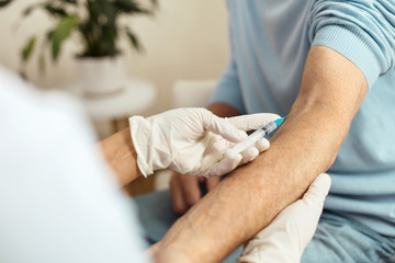 Close up of a syringe needle being inserted into the vein