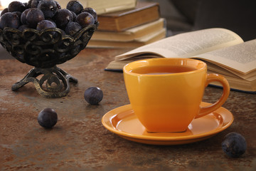 A cup of tea and plum on the table