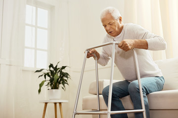 Nice persistent man standing up from the sofa
