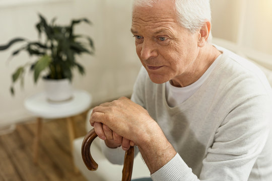 Cheerless elderly man sitting in his house