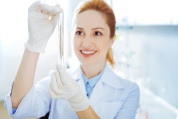 Charming lab assistant examining sample of ear