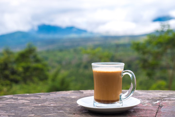 Hot coffee on table with the great view of East Java coffee plantation in background, Indonesia - obrazy, fototapety, plakaty