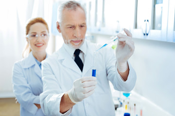 Attentive man doing experiment with reagents