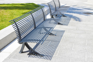 New paving made with stone blocks in an italian pedestrian zone with flowerbed and modern steel bench