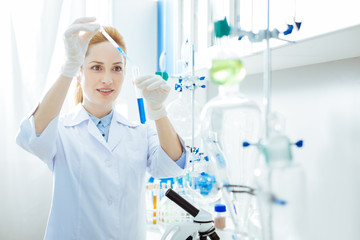 Delighted lab assistant mixing reagents