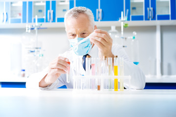Fototapeta premium Portrait of serious practitioner that mixing reagents